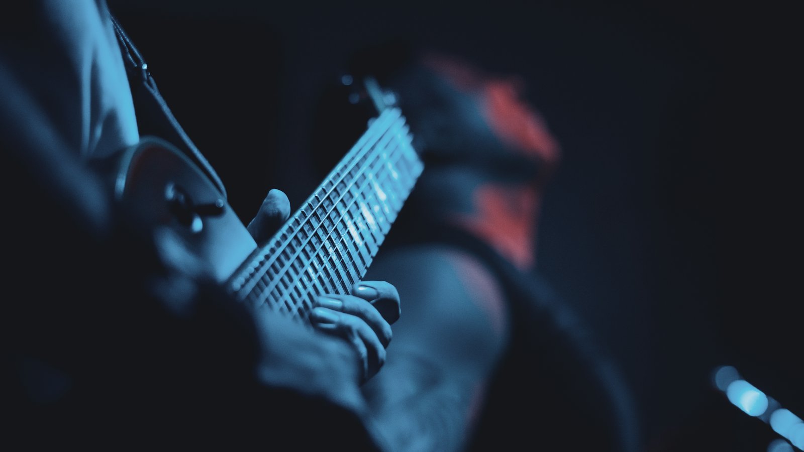Guitarist playing electric guitar in a dark studio
